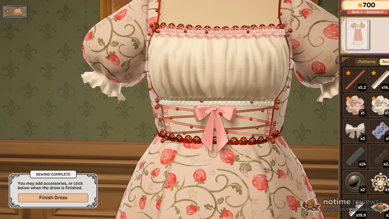 Dressmaker: a strawberry print dress with a pink bow, lace trim and beading on the mannequin